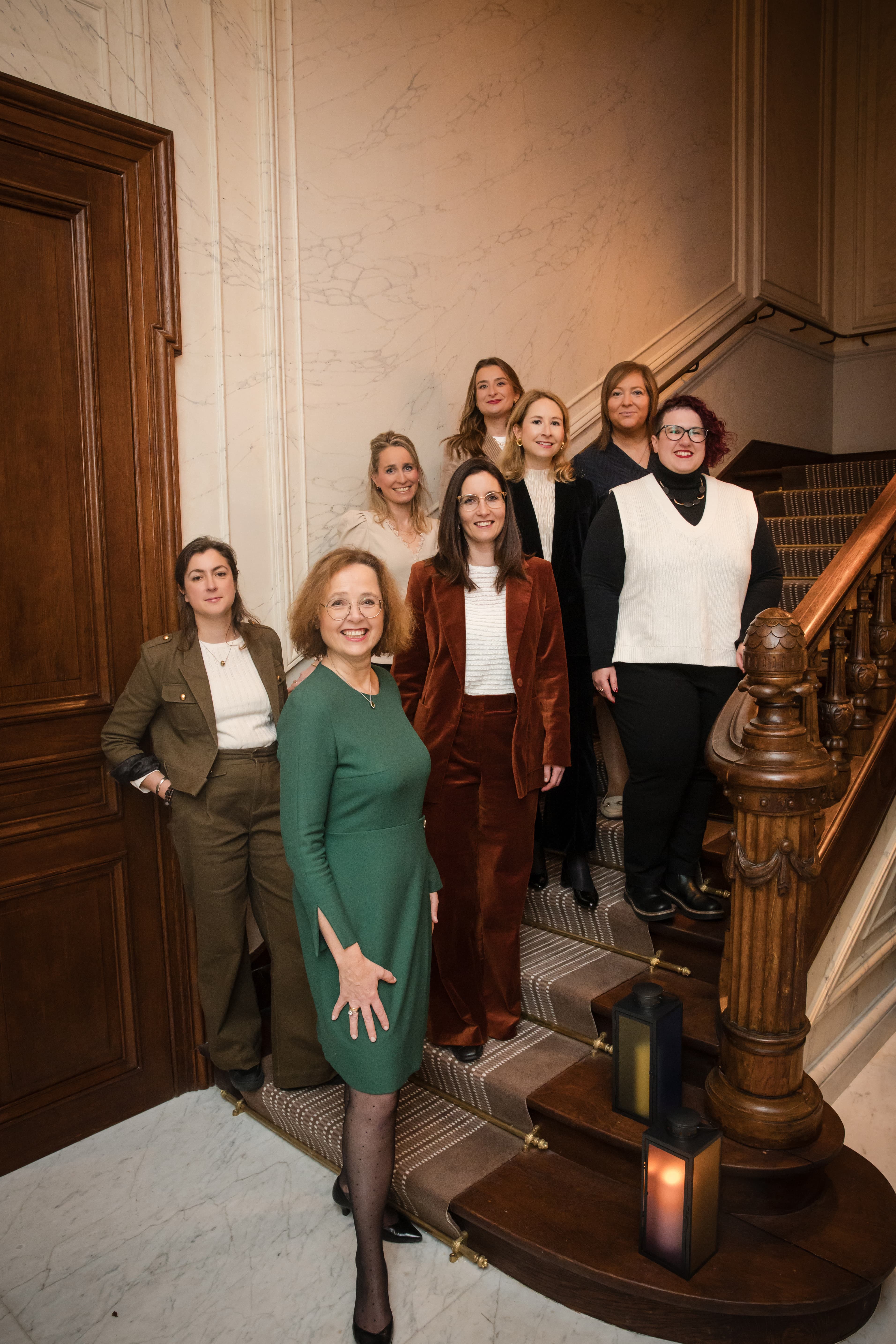 The Luxembourg Convention Bureau team of eight women posing on an elegant marble staircase